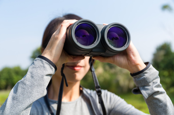 mujer mirando a través de prismáticos al aire libre
 - Foto, Imagen