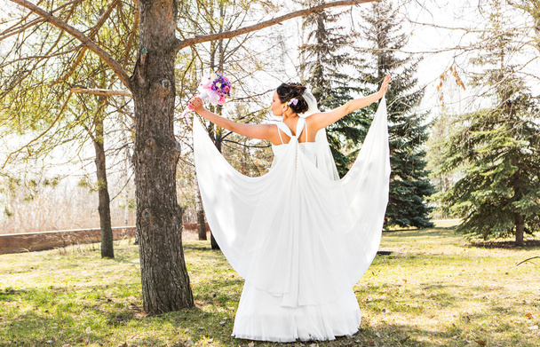 young brunette bride  in the park on nature with a flowing veil. - Foto, Imagem