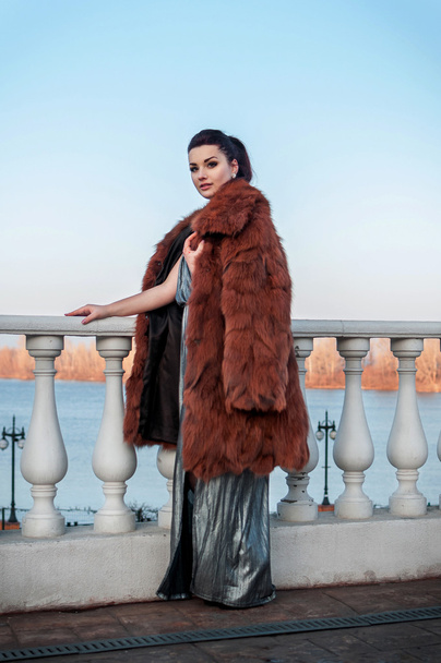 lüks kürk ceket ve deri eldiven giymiş siyah saçlı seksi glamour kadın moda açık fotoğrafı - Fotoğraf, Görsel