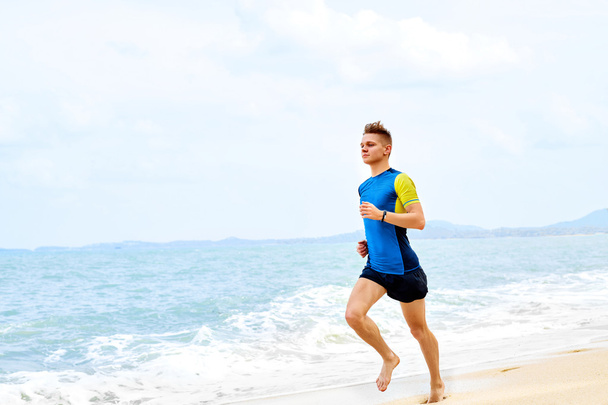 Wellness. Fit Athletic Man Running On Beach,Jogging During Worko - 写真・画像