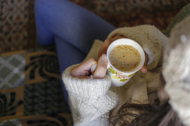 Um cappuccino copo com mão de mulher
 - Foto, Imagem