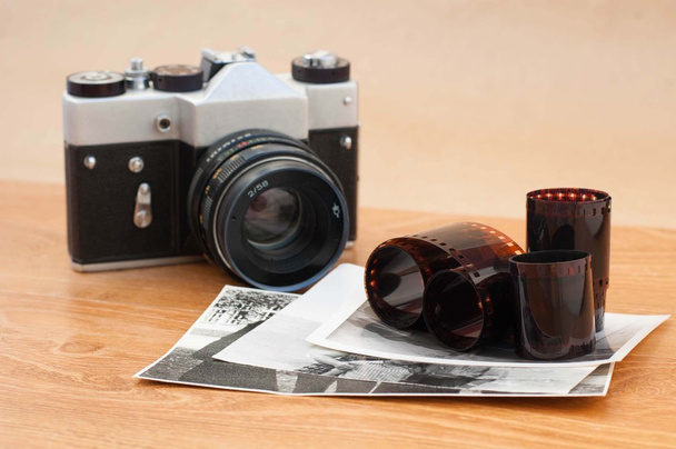 Vintage camera, foto's en negatieven op houten tafel - Foto, afbeelding