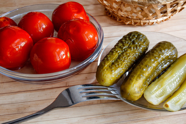 pickled tomatoes and cucumbers on the table - Фото, изображение