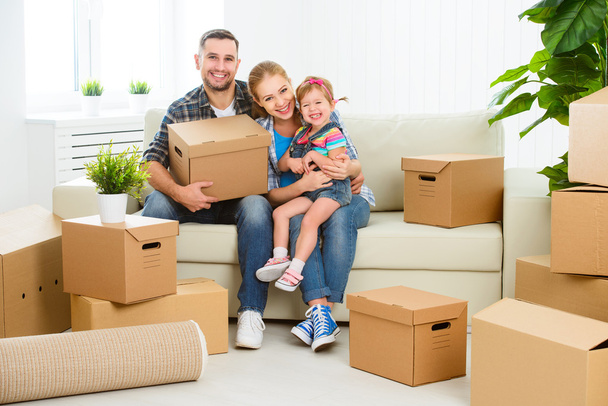 Μετακίνηση στο νέο σπίτι. Ευτυχισμένη οικογένεια με κουτιά από χαρτόνι - Φωτογραφία, εικόνα