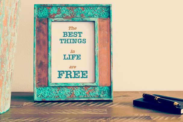 Мотивационная цитата, написанная на винтажной рамке для фотографий Лучшие вещи в жизни БЕСПЛАТны
 - Фото, изображение