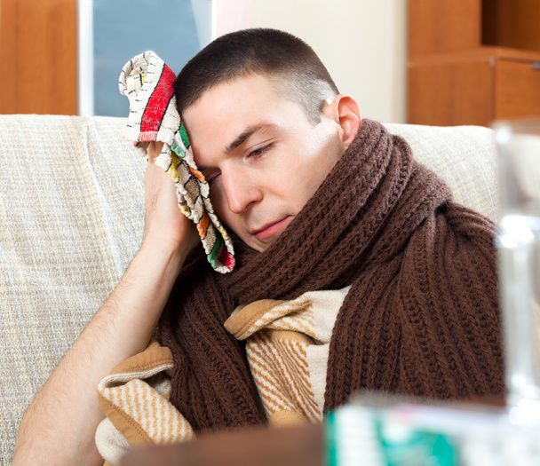 Suffering man in scarf  stuping  towel to head - Photo, Image