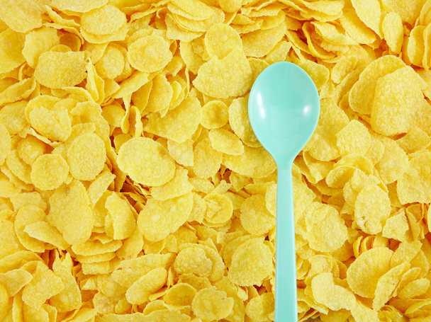 Вкусные золотые хлопья кукурузы и пластиковые ложки
 - Фото, изображение