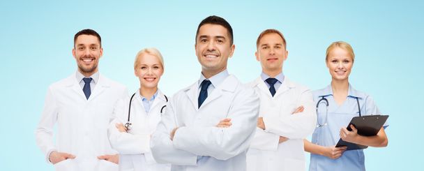 group of smiling doctors with clipboard - Fotó, kép