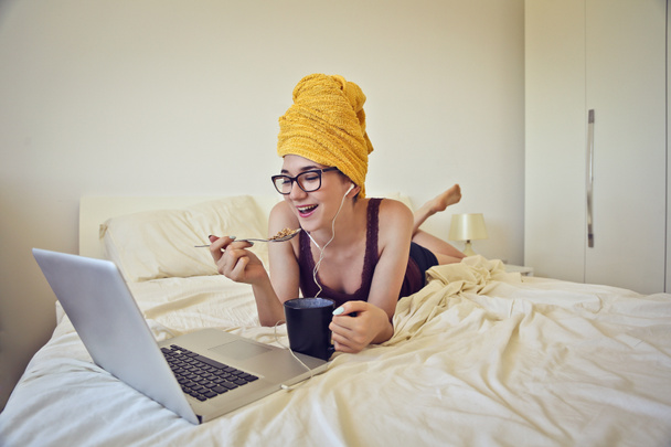 Γυναίκα που χρησιμοποιούν τον υπολογιστή στο κρεβάτι - Φωτογραφία, εικόνα