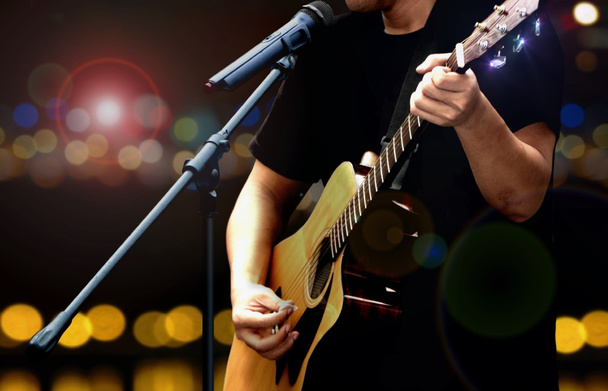 Guitarrista en el escenario tocando con guitarra acústica
 - Foto, Imagen