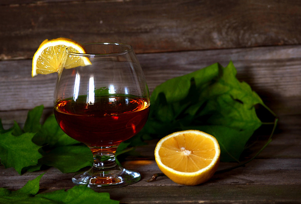 Glas cognac met citroen - Foto, afbeelding