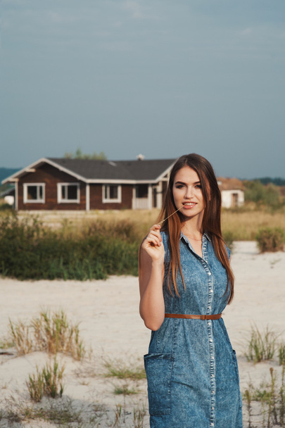 ruskeat hiukset maaseudun nainen seisoo hiekalla vastaan ranch house
 - Valokuva, kuva