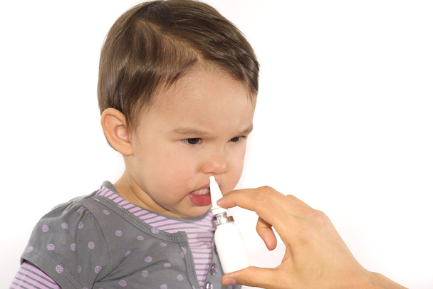 parent's hand of a girl applies a nasal spray - Photo, Image