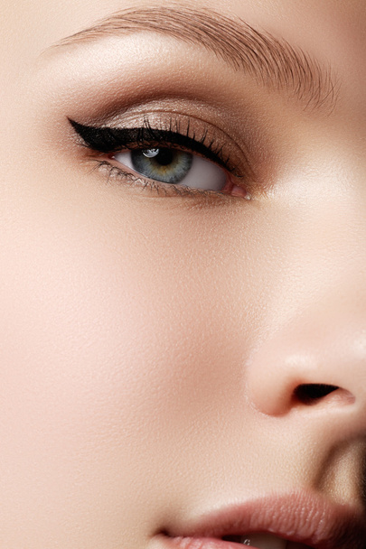 Косметика та макіяж. Красиве жіноче око з сексуальним чорним лайнерним макіяжем. Мода велика стрілка на повіку жінки. Шикарний вечірній макіяж
 - Фото, зображення