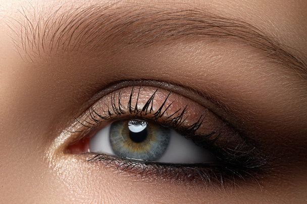 Elegantie close-up van vrouwelijke oog met klassieke donker bruin rokerige make-up. Macro-opname van vrouw gezicht deel. Schoonheid, cosmetica en make-up. - Foto, afbeelding