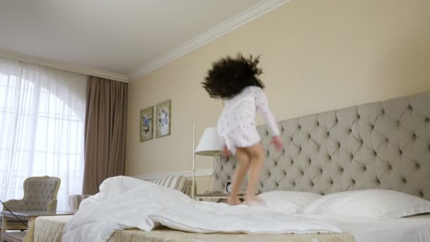 Милая маленькая девочка прыгает на кровати
 - Кадры, видео