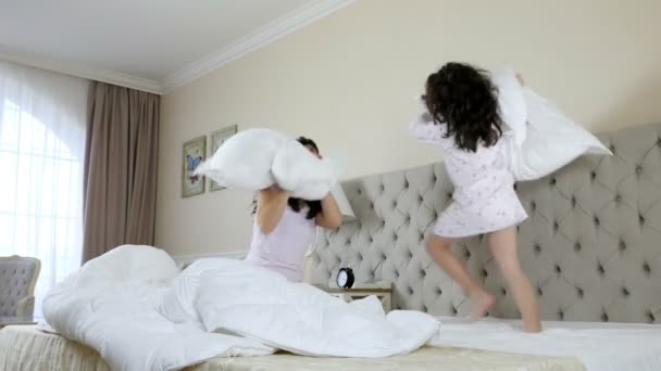 Matka i córka walczą na poduszki w sypialni - Materiał filmowy, wideo