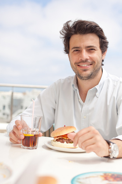 Young man eating a hamburger - Photo, Image