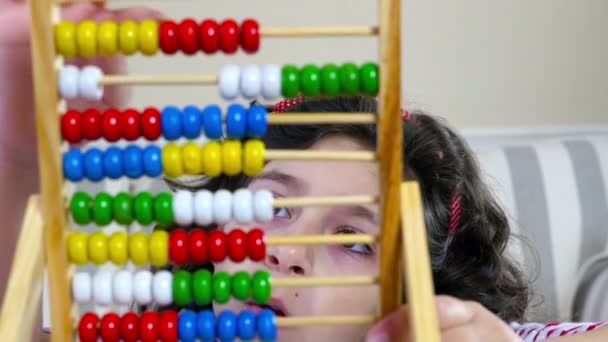 Cute little girl counting with abacus at home, close up - Footage, Video