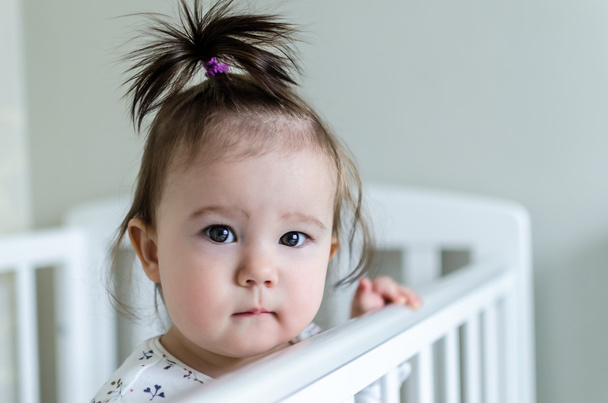 Portrait of adorable little baby girl staying at her bed - Foto, Imagem