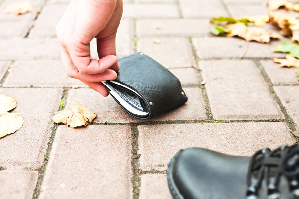 Člověk vyvolává černou peněženku s penězi na ulici - Fotografie, Obrázek