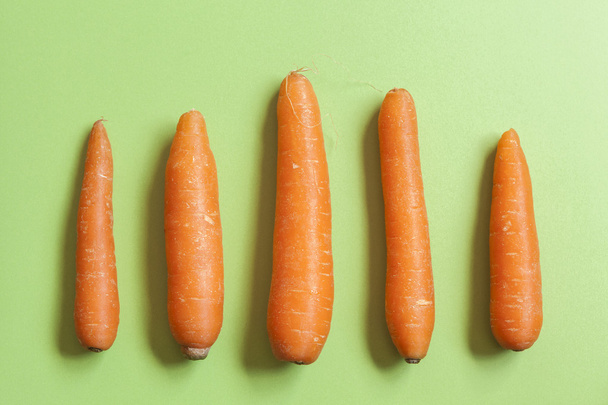 jogo de cenouras em uma bancada verde
 - Foto, Imagem
