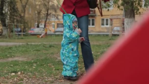 Маленький хлопчик грає зі своєю матір'ю з іграшковою машиною в парку
 - Кадри, відео