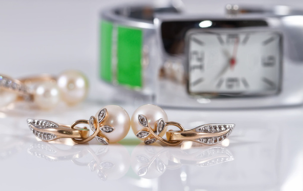 золотые украшения с жемчугом и элегантные женские часы
 - Фото, изображение