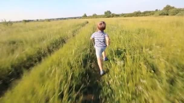 Boy running across hill in slowmotion - Video