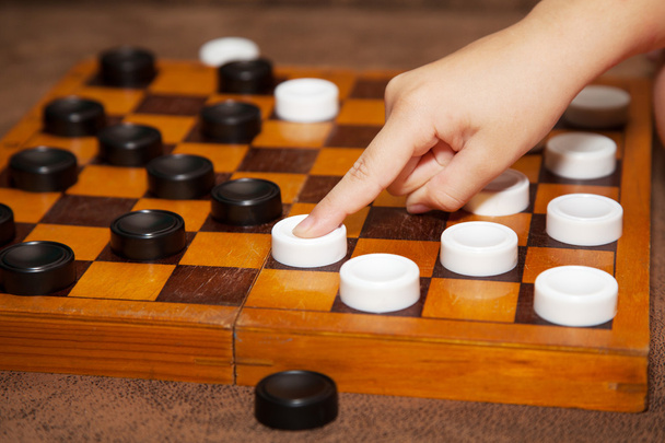 mão da criança move a peça para o tabuleiro de xadrez
 - Foto, Imagem