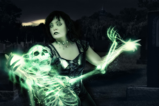 Sorceress casting spells on skeleton. - Foto, Imagen