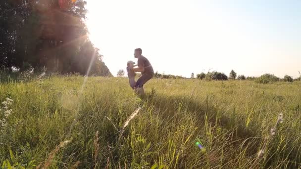 Niño caminando con su padre en un campo de hierba en cámara lenta
 - Imágenes, Vídeo