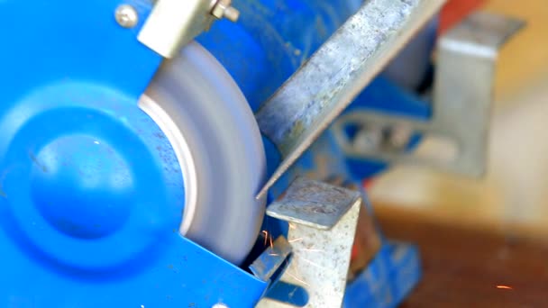 Worker grinding metal component on bench grinder - Footage, Video