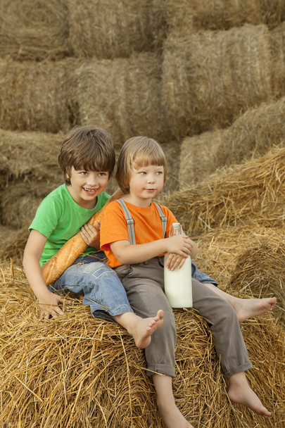 teenager on a haystack with bread and milk - Foto, Bild