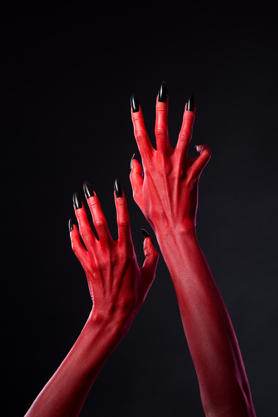 Red devil hands with black nails - 写真・画像