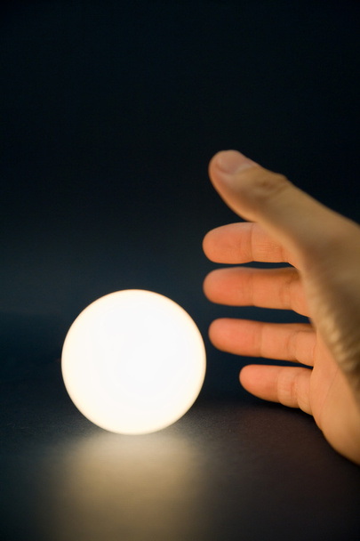 Hand touching a bright ball - Фото, зображення