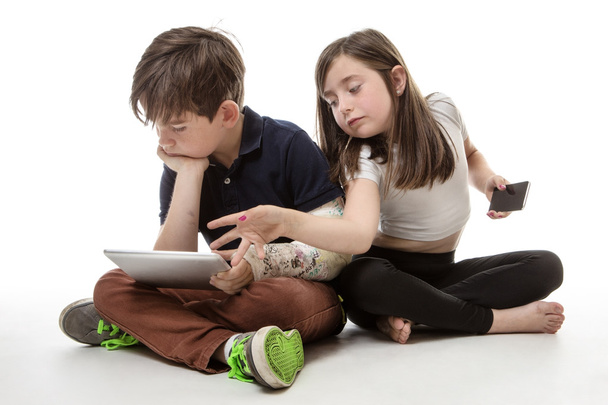 children engrossed in technology - Foto, afbeelding
