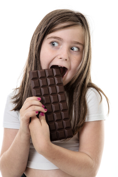 Küçük kız çikolata yiyor.  - Fotoğraf, Görsel