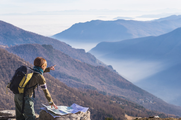 Žena čte turistickou mapu a poiting na prst do Alp - Fotografie, Obrázek