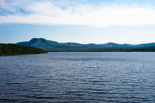 Λίμνη ανάμεσα σε δασώδεις λόφους και το βουνό - Φωτογραφία, εικόνα