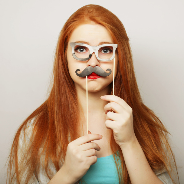 Young woman wearing fake mustaches. - Fotoğraf, Görsel