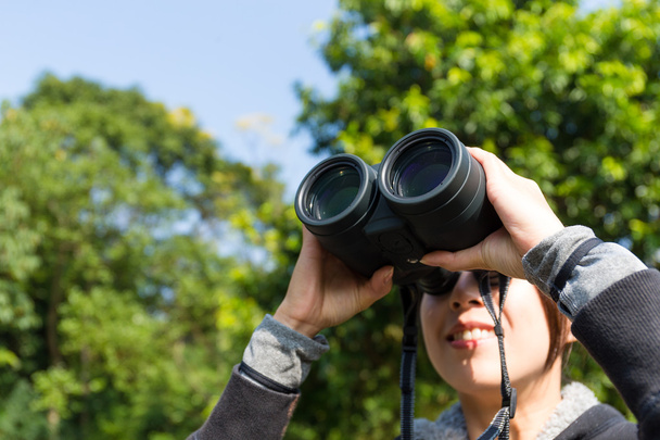 vrouw op zoek door middel van verrekijkers in de open lucht - Foto, afbeelding