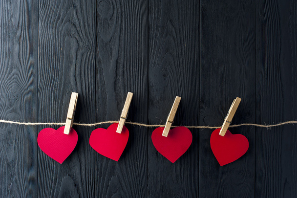 Red hearts with clothespins on dark background - Foto, Imagem
