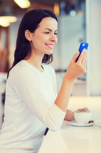 smiling woman with smartphone and coffee at cafe - Photo, image