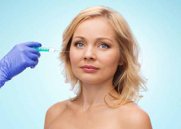 woman face and beautician hand with syringe - Foto, Bild