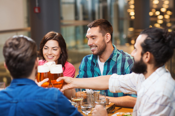 friends dining and drinking beer at restaurant - Photo, Image