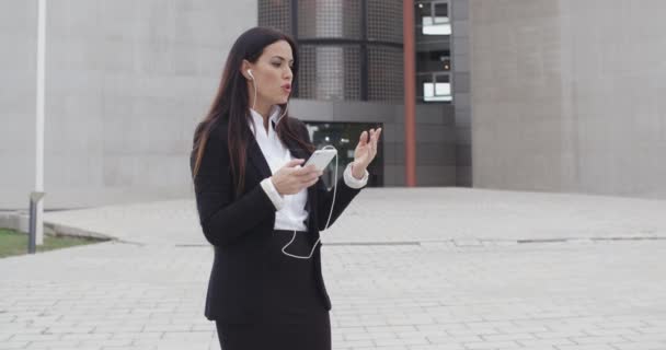 businesswoman taking call using earplugs - Séquence, vidéo