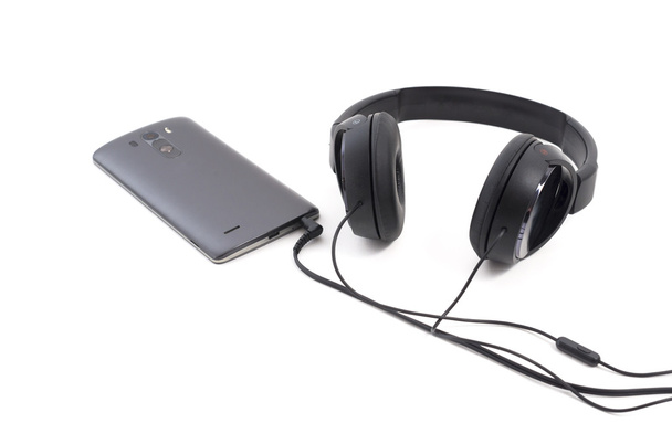 Headphones and smartphone. Isolated on white background - Photo, Image
