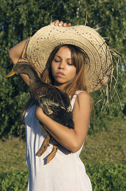girl in a hat with a goose - Foto, afbeelding