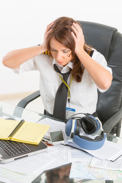 Piloto de aerolínea con exceso de trabajo en la oficina
 - Foto, Imagen